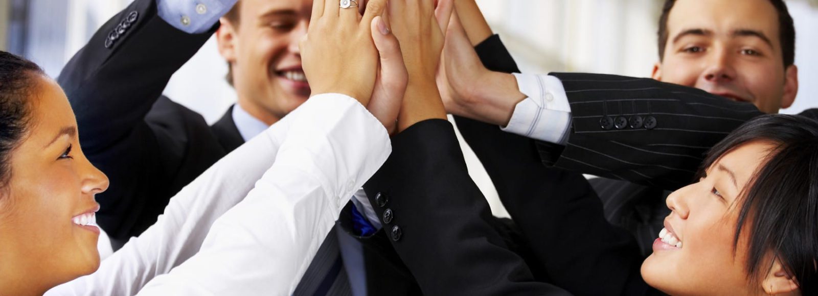 A stock photo of employees high-fiving one another