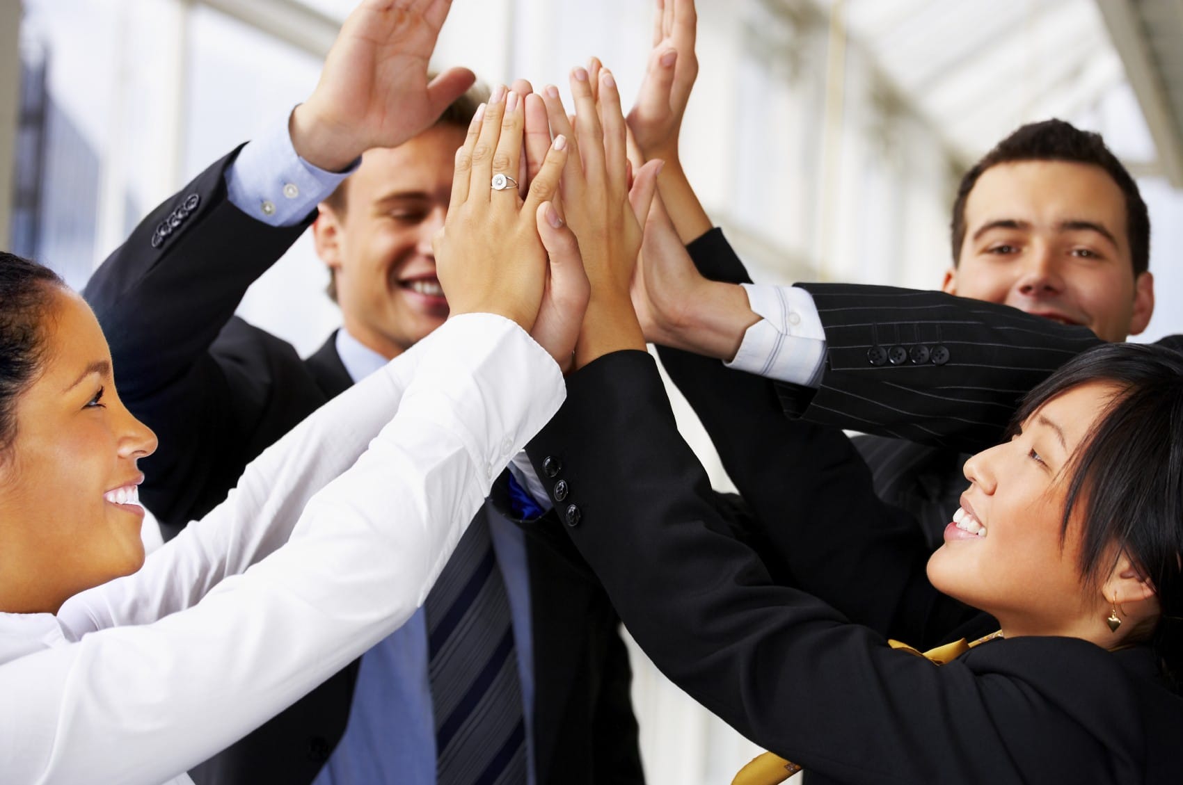 A stock photo of employees high-fiving one another
