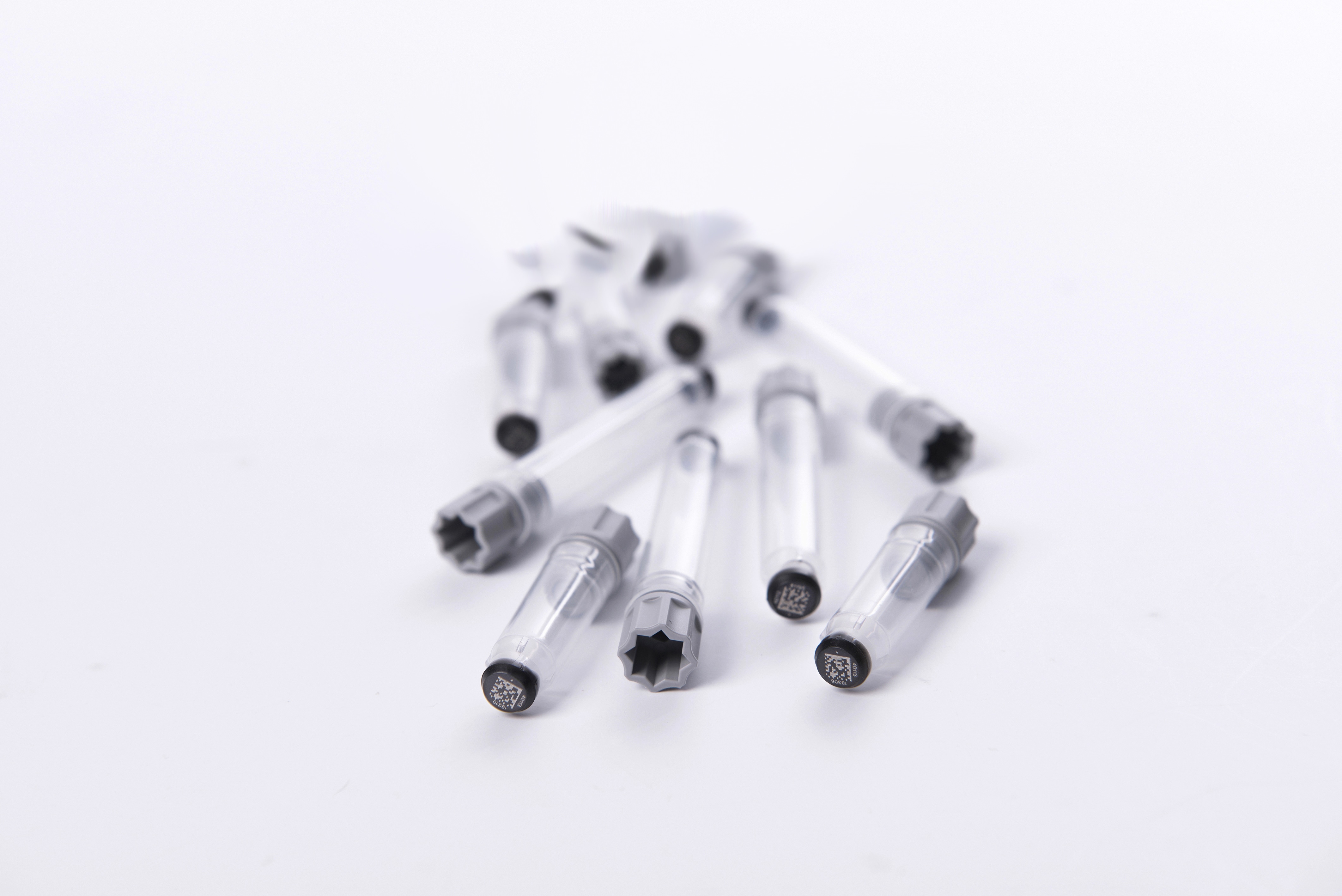 A pile of screw cap tubes precapped with grey screw caps with 2D Data-Matrix codes