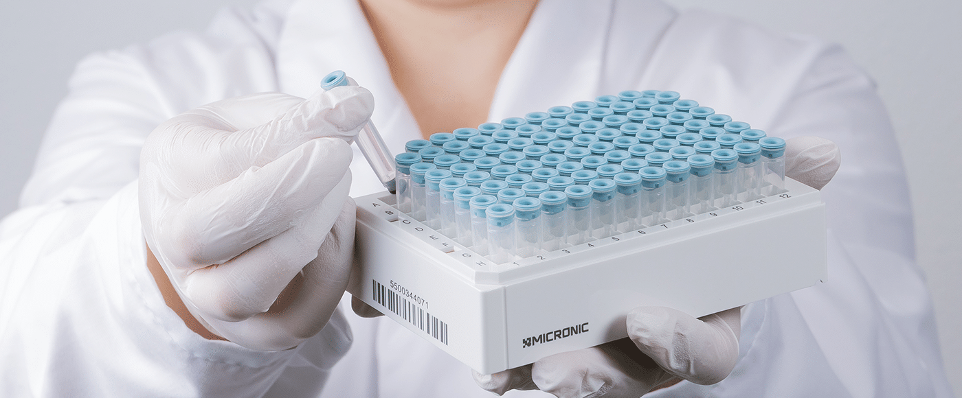 Micronic sample tube with TPE Lyo Cap being removed from a 96-well rack