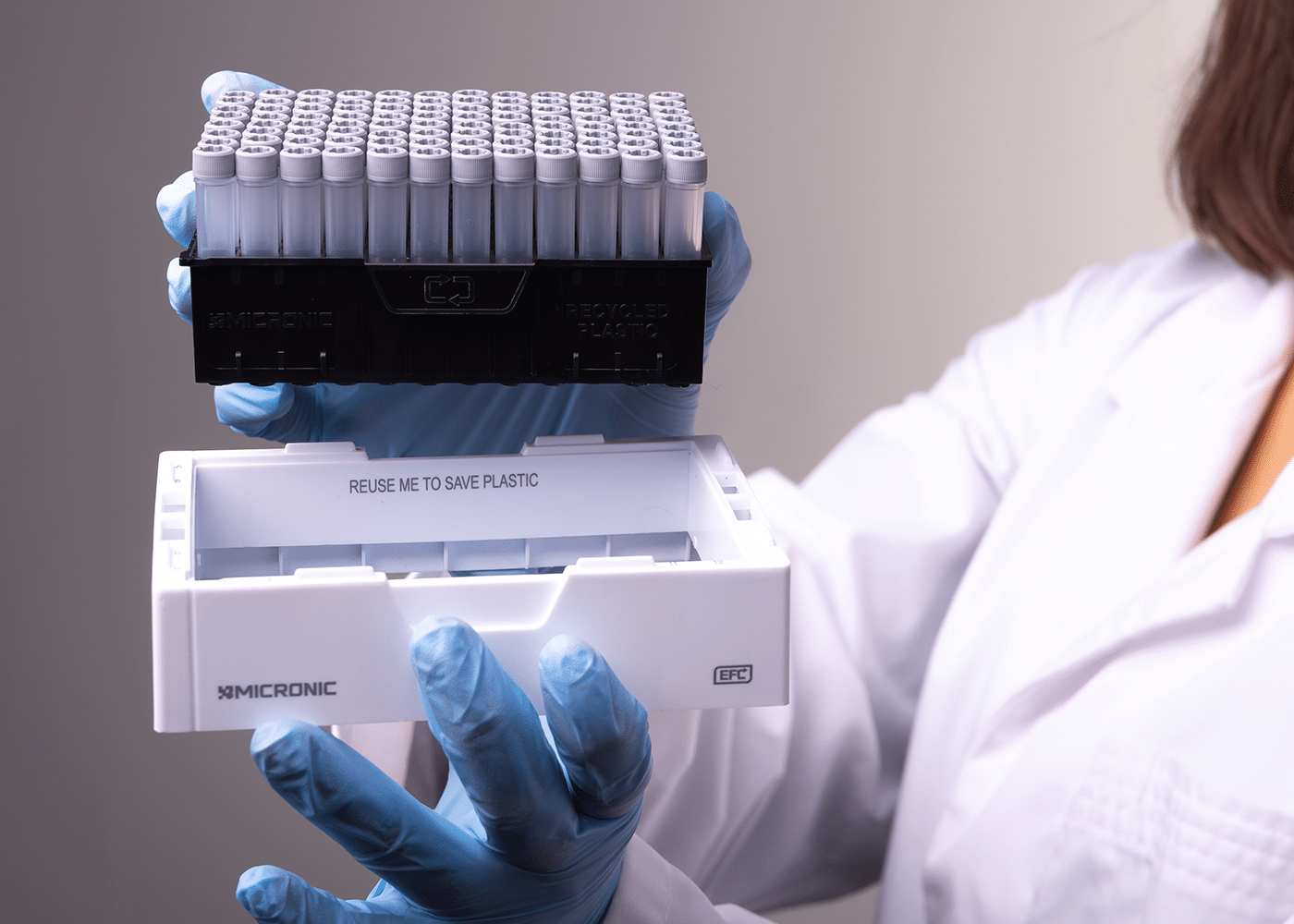 Scientist holding Micronic rack showing reusable rack components